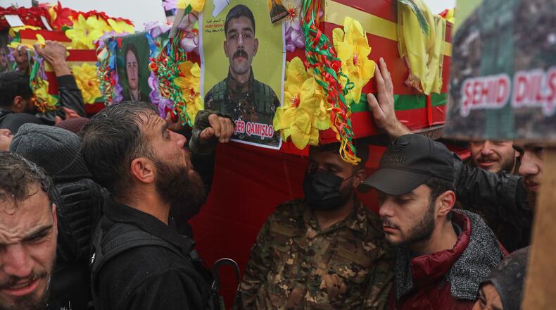 Soldiers carry coffins during the funeral of Kurdish-led Syrian Democratic Forces (SDF) fighters killed earlier this month during clashes with Syrian government forces, in Qamishli, northeastern Syria, Wednesday, Jan. 28, 2026. (AP Photo/Baderkhan Ahmad)