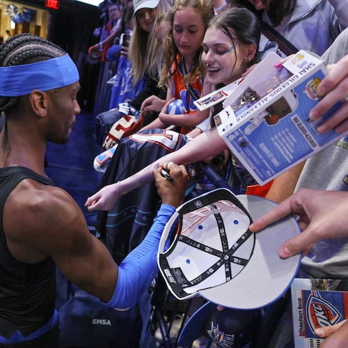 Oklahoma City Thunder guard Shai Gilgeous-Alexander, bottom left, gives autographs to fans before Game 1 of a first-round NBA playoffs basketball series against the Phoenix Suns, Sunday, April 19, 2026, in Oklahoma City. (AP Photo/Nate Billings)