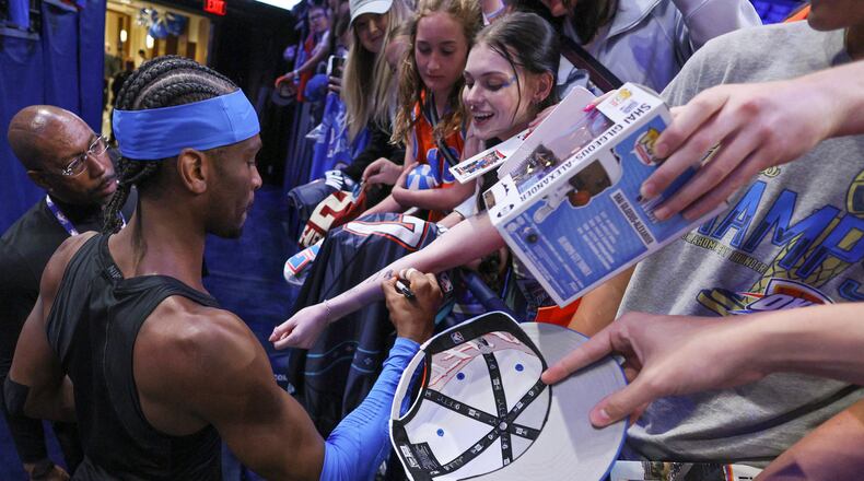 Oklahoma City Thunder guard Shai Gilgeous-Alexander, bottom left, gives autographs to fans before Game 1 of a first-round NBA playoffs basketball series against the Phoenix Suns, Sunday, April 19, 2026, in Oklahoma City. (AP Photo/Nate Billings)