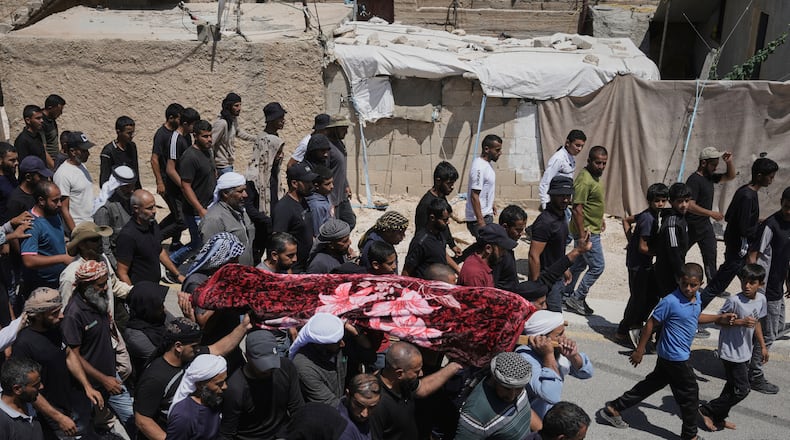 FILE -Mourners carry the body of Palestinian activist Awdah Al Hathaleen, who was killed by Israeli settler according to Palestinian health officials, during his funeral in the West Bank Bedouin village of Umm al-Khair, Aug. 7, 2025. (AP Photo/Mahmoud Illean, File)