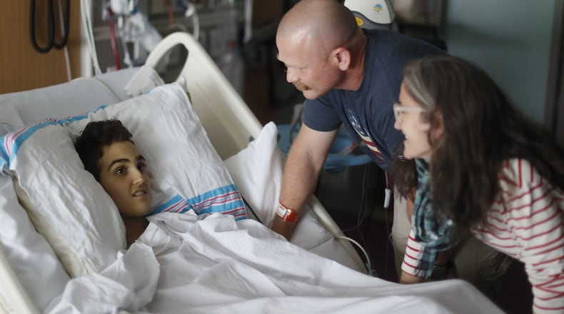 May 30, 2019 - Atlanta - Logan Droke and his father, Randall, and stepmother, Veronique, spend some time together in his hospital room. Logan, 18, from Canton, facing his fourth battle with leukemia at Children’s Healthcare of Atlanta at Scottish Rite, is set to graduate from Creekview High School on Friday. Firefighters in two departments are rallying behind the teenager by raising money to help pay for treatments. Bob Andres / bandres@ajc.com