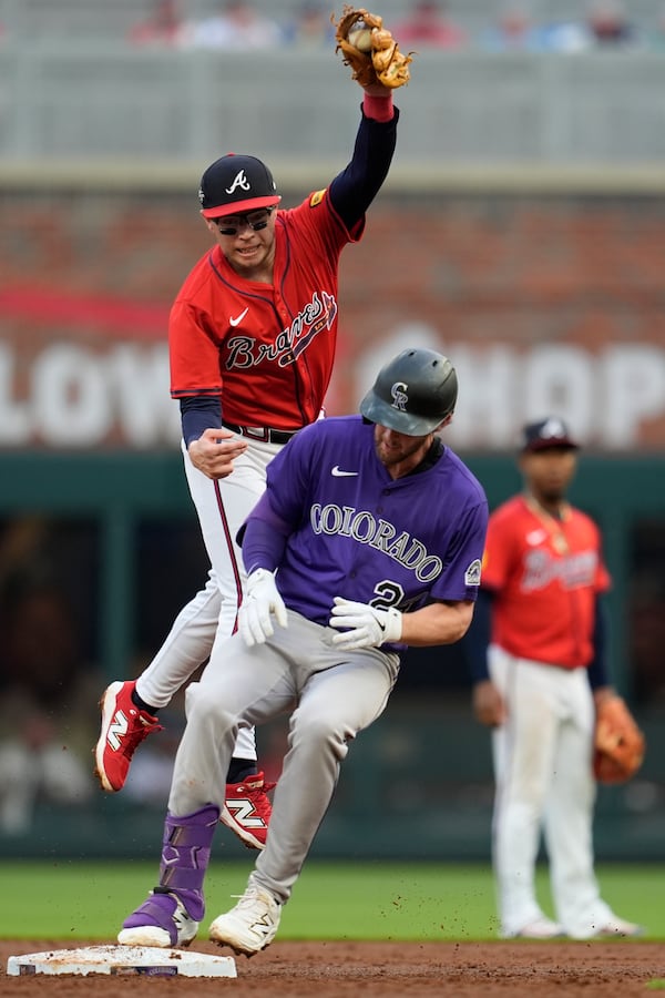 Atlanta Braves shortstop Nick Allen (2) attempts a tag on Colorado Rockies' Ryan McMahon (24) third inning of a baseball game, Friday, June 13, 2025, in Atlanta. (AP Photo/Mike Stewart)
