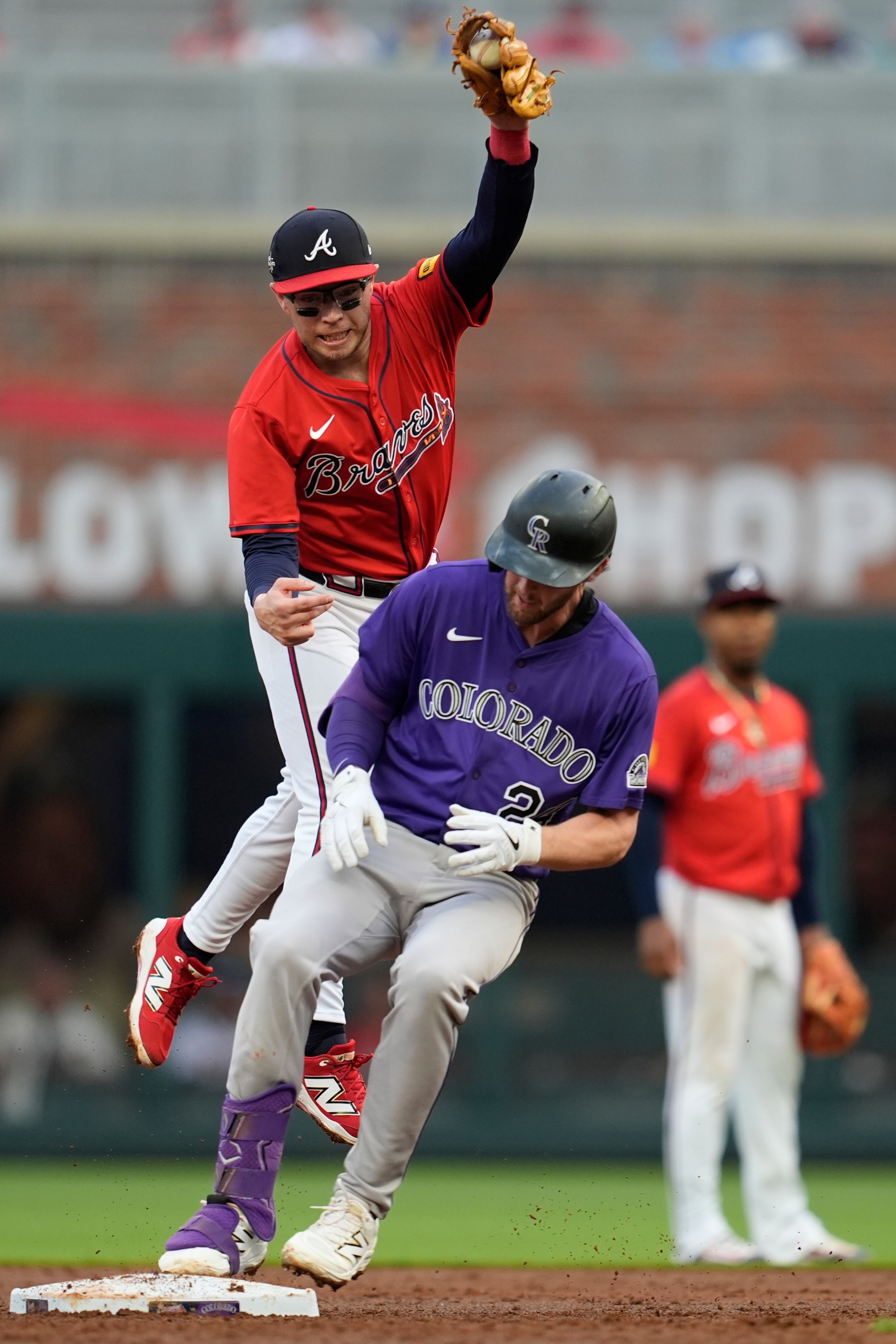 Braves shortstop Nick Allen attempts a tag on the Colorado Rockies' Ryan McMahon during the third inning Friday at Truist Park in Atlanta. (Mike Stewart/AP)