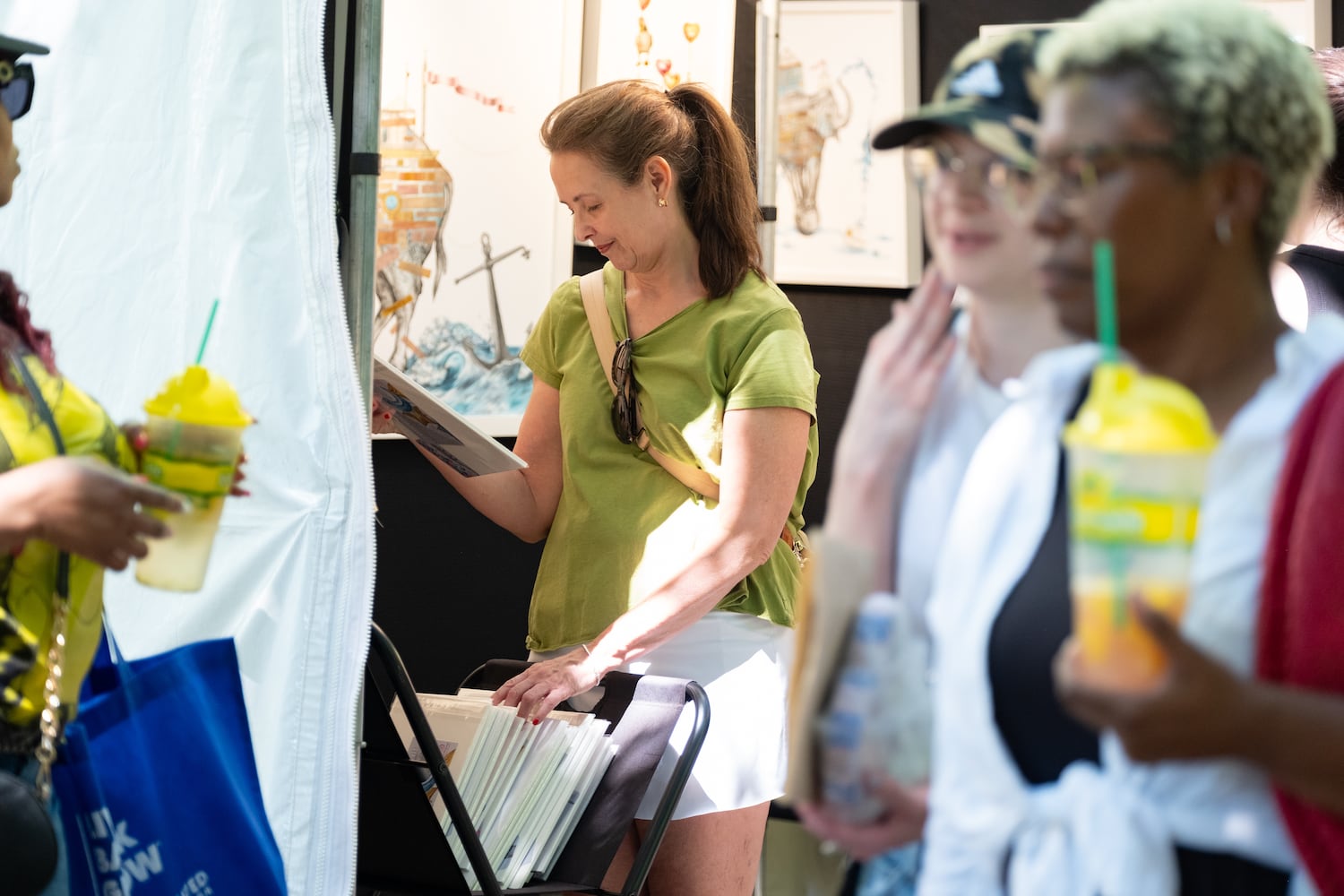 Beth Pann looks at prints at Amanda Outcalt’s booth at the Atlanta Dogwood Festival at Piedmont Park on Saturday, April 11, 2026. (Ben Gray for the AJC)
