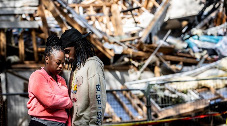 Destiny Raymond and Kris Hubbard stand in front of what is left of their Austell apartment Tuesday, April 25, 2023. (Steve Schaefer/steve.schaefer@ajc.com)