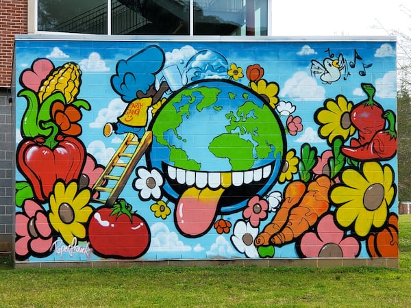 The Earth looks hungry for fresh produce in this southwest Atlanta mural by Paper Frank (Frank Dunson). (Courtesy of Arthur Rudick)