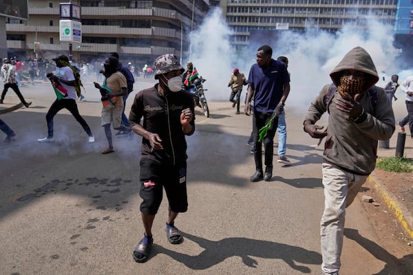 Protesters scatter as police fire teargas at them during a demonstration in downtown Nairobi, Kenya, Wednesday, June 25, 2025. (AP Photo/Brian Inganga)