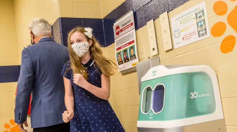 Lexi Walton, 11, finishes up her first use of "Iggy," 3Oe Scientific's aqueous ozone hand-rinsing station that was installed in the Bryant Elementary School cafeteria in Mableton. The Iggy hand-rinsing stations installed in Cobb schools have stopped working or malfunctioned more than 100 times since their rollout began in 2020, district records show. (Jenni Girtman for The Atlanta Journal-Constitution)