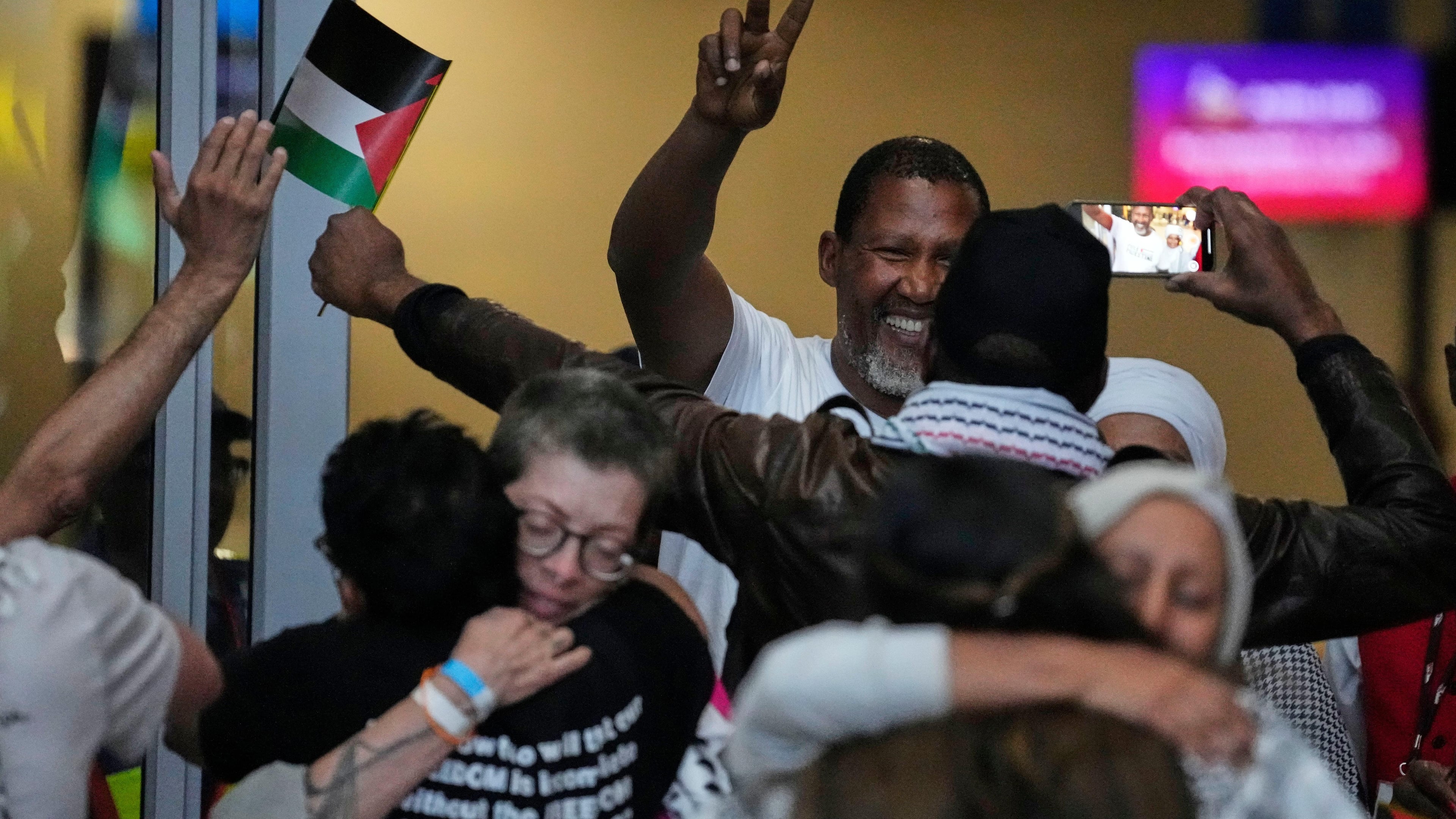 Mandla Mandela, showing victory sign and his fellow members of the Global Sumud Flotilla, at OR Tambo International Airport, in Johannesburg, South Africa, Wednesday, Oct. 8, 2025. (AP Photo/Themba Hadebe)