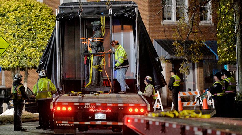 Workers load a Confederate statue onto a truck after it was removed from its spot in front of the historic Chatham County Courthouse early Wednesday in Pittsboro, N.C.
