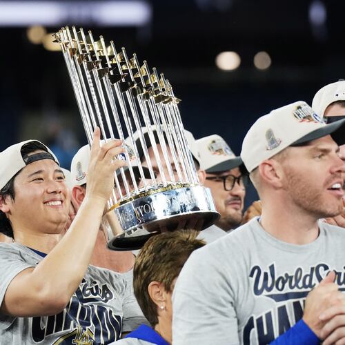 Los Angeles Dodgers pitcher Shohei Ohtani, left, lifts the trophy as the Dodgers celebrate after defeating the Toronto Blue Jays in Game 7 of baseball's World Series, Sunday, Nov. 2, 2025, in Toronto. (Nathan Denette/The Canadian Press via AP)