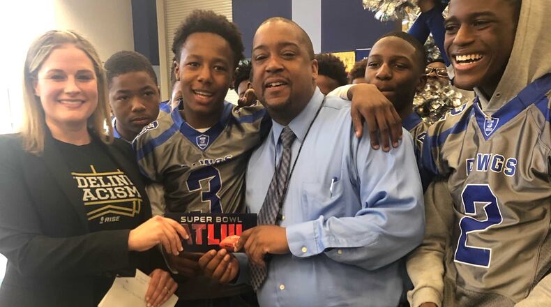 Brown Middle School teacher and football coach Ernest Davis, in blue shirt and tie, found out Friday he had won a ticket to the Super Bowl, to be played Feb. 3 in Atlanta.