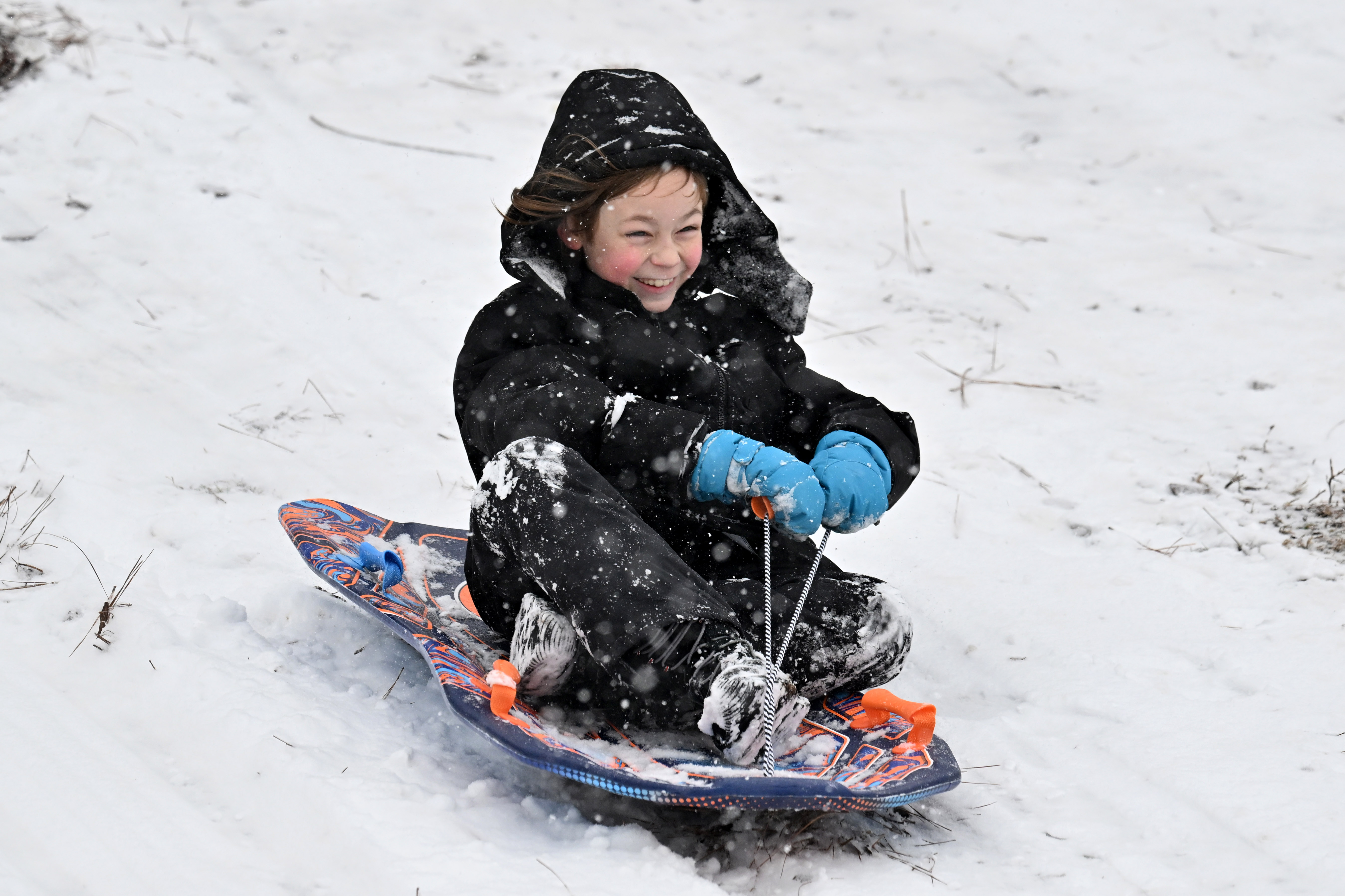 Benny Myers, 9, sleds down a hill at Little Mulberry Park in Dacula on Saturday. Although Gen. Beauregard Lee saw his shadow and predicted six more weeks of winter, it won't be as cold and snowy as the past couple of weeks. (Hyosub Shin/AJC)
