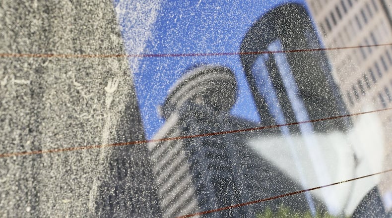 A parked car at John Portman Blvd. and Peachtree Center Avenue reflects a pollinated view of the Atlanta skyline from the back window in April 2013. JOHN SPINK / JSPINK@AJC.COM