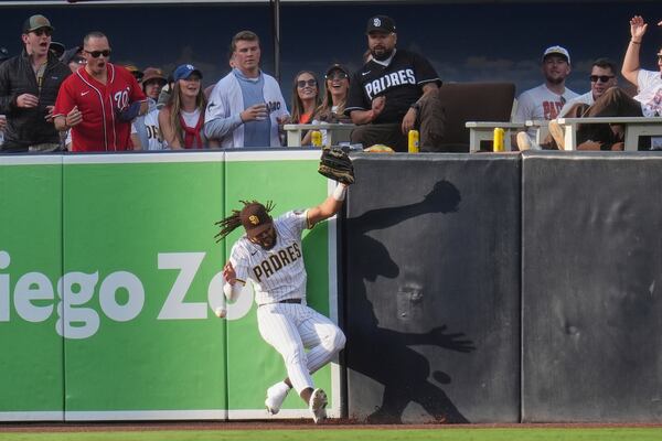 San Diego Padres right fielder Fernando Tatis Jr. can't make the catch at the wall off a hit for a double by Atlanta Braves' Matt Olson during the sixth inning of a baseball game Saturday, March 29, 2025, in San Diego. (AP Photo/Gregory Bull)