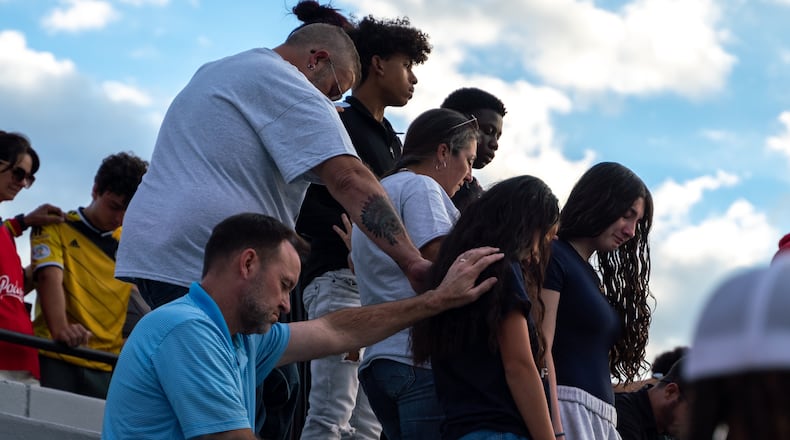 Families bow their heads in prayer. Hundreds gather at Flowery Branch High School  to celebrate the life of Ricky Aspinwall II. Sunday, Sept. 8, 2024. Richard Aspinwall, a football assistant coach and teacher at Apalachee High School in Barrow County, was one of four people killed in the Sept. 4 school shooting.  (Ben Hendren for The Atlanta Journal-Constitution)