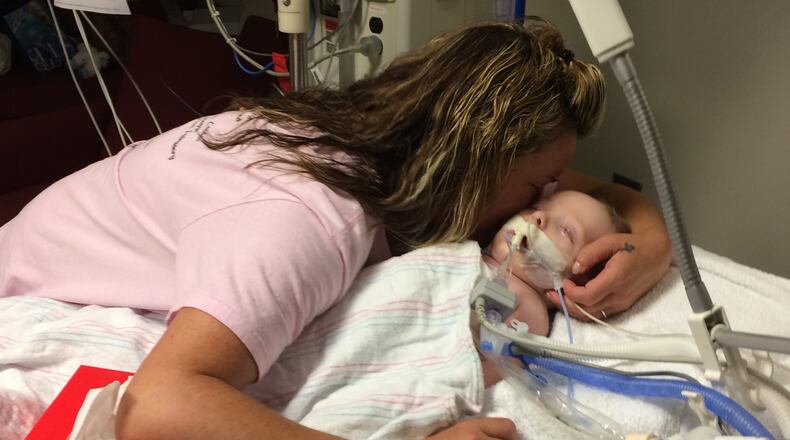 Dinah Paige Whited receives a kiss from her maternal grandmother, Paige Cason-Barrett, Wednesday night at Children's Healthcare of Atlanta at Egleston. The Atlanta Journal-Constitution was in Dinah's room with the permission of Paige Cason-Barrett. Craig Schneider / cschneider@ajc.com
