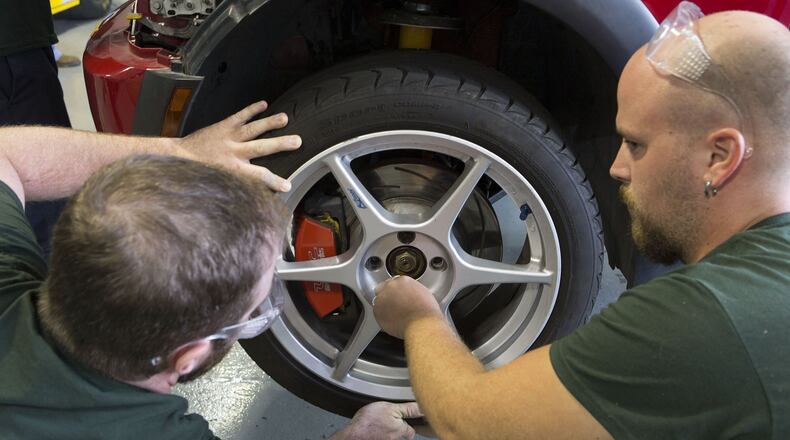 Mark Smith (left) & Chris Hearn replace a tire in the Motorsports Vehicle Technology Program at Lanier Technical College in Oakwood, Ga. About 60% of high school students in Georgia’s dual enrollment program take courses at Lanier Tech and the other 21 Technical College System of Georgia schools.