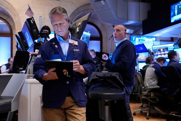 Bobby Charmak, left, and others work on the floor at the New York Stock Exchange in New York, Monday, April 7, 2025. (AP Photo/Seth Wenig)