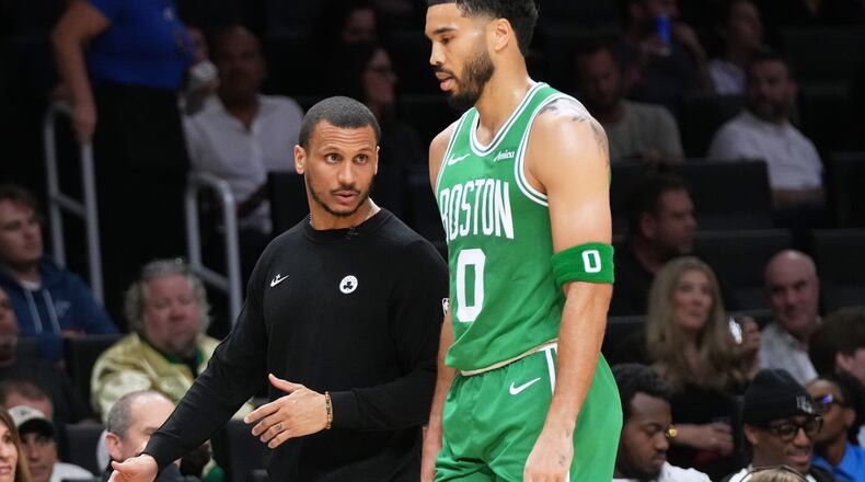 Boston Celtics head coach Joe Mazzulla, left talks with forward Jayson Tatum (0) during the first half of an NBA basketball game against the Miami Heat, Wednesday, April 1, 2026, in Miami. (AP Photo/Lynne Sladky)