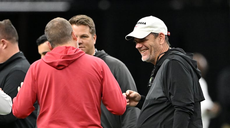 Bulldogs offensive coordinator Mike Bobo (right) — pictured during Sugar Bowl practice in December — and defensive coordinator Glenn Schumann received raises this offseason and will make $2.2 million for the 2026 season. (Hyosub Shin/AJC)