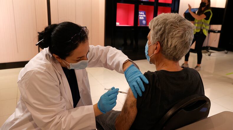 Safeway pharmacist Shahrzad Khoobyari administers a Pfizer COVID-19 booster vaccination into the arm of Norman Solomon at a vaccination booster shot clinic on Oct. 1, 2021 in San Rafael, California. (Justin Sullivan/Getty Images/TNS)