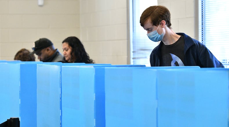 William Bennett (right) casts his ballot at an early voting location in Mountain Park Activity Building in Stone Mountain on Saturday, October 22, 2022.  (Hyosub Shin / Hyosub.Shin@ajc.com)