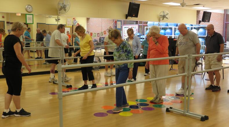 Fitness instructor Katy Pate (left) leads a Parkinson’s support class at the McCleskey-East Cobb Family YMCA. Free six-month YMCA family memberships are available for those with Parkinson’s thanks to a grant from the National Parkinson Foundation. Contributed by Laura Berrios