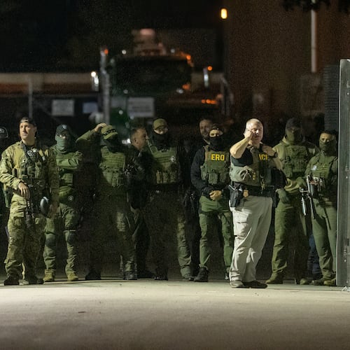 Federal law enforcement officers stand guard in the open gate of the fence built on Beach Street outside the Broadview ICE processing facility in suburban Broadview, Tuesday, Oct. 14, 2025. (Tyler Pasciak LaRiviere/Chicago Sun-Times via AP)