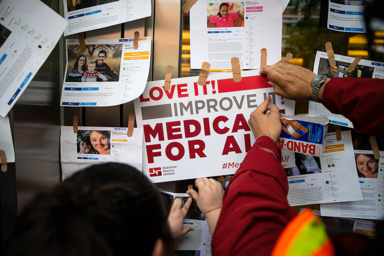 Examples of GoFundMe pages for patients who used crowdfunding to cover medical expenses are posted on doors for the headquarters of Pharmaceutical Research and Manufacturers of America during a “Medicare for All” rally in Washington, April 29, 2019. (Al Drago/The New York Times)