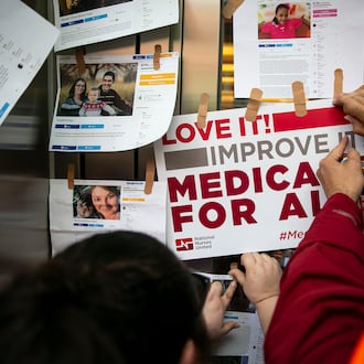 Examples of GoFundMe pages for patients who used crowdfunding to cover medical expenses are posted on doors for the headquarters of Pharmaceutical Research and Manufacturers of America during a “Medicare for All” rally in Washington, April 29, 2019. (Al Drago/The New York Times)