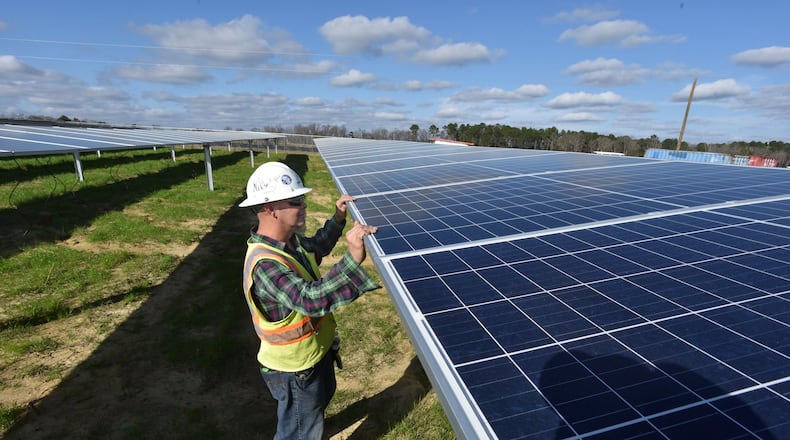 A worker with Solar Panel Solutions inspects solar panels in Bronwood, Ga. All three Democratic candidates running in the primary for the District 3 Public Service Commission seat say they would push to accelerate Georgia's shift toward solar and other renewable energy sources. HYOSUB SHIN / HSHIN@AJC.COM