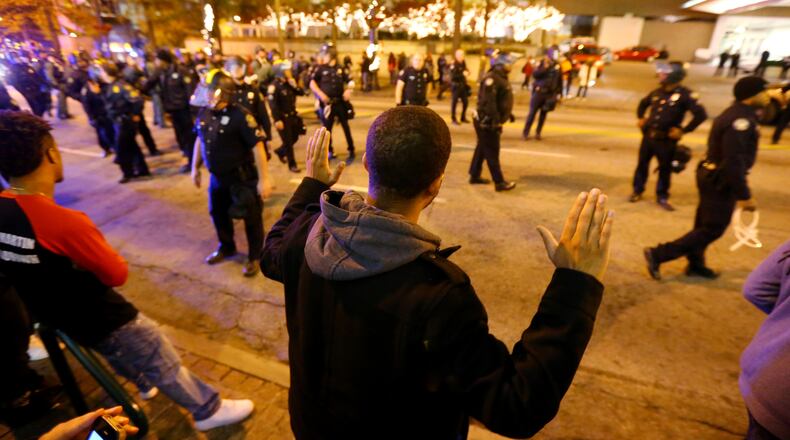 112514 ATLANTA: Protesters face off with Atlanta police after they forced them out of the road to the side walk on Peachtree Street in Atlanta in the wake of the grand jury decision not to indict officer Darren Wilson in the shooting death of Ferguson, MO., teen Michael Brown on Tuesday, Nov. 25, 2014. CURTIS COMPTON / CCOMPTON@AJC.COM
