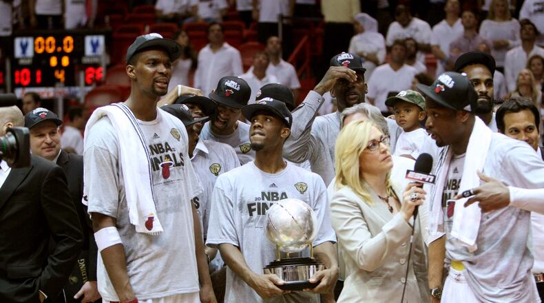 Heat players Chris Bosh (from left), Norris Cole (30), and Dwyane Wade (shown talking with ESPN's Doris Burke), begin celebrating after a Game 7 win over the Celtics that puts Miami in the 2012 NBA Finals.
