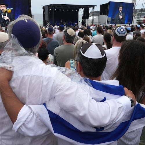 FILE - People attend a ceremony to mark the National Day of Reflection for victims and survivors, at Bondi Beach in Sydney, Sunday, Dec. 21, 2025, following the Bondi shooting on Dec. 14. (AP Photo/Mark Baker,File)