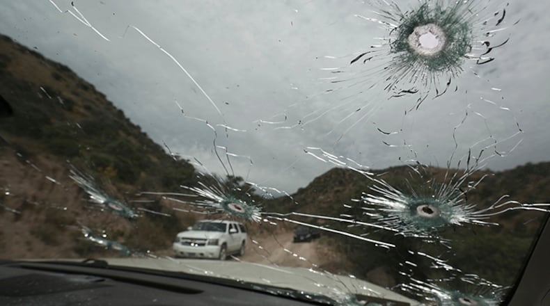 Bullet-riddled vehicles that members of the extended LeBaron family were traveling in sit parked on a dirt road near Bavispe, at the Sonora-Chihuahua state border, Mexico, on Wednesday. Three women and six of their children, related to the extended LeBaron family, were gunned down in an attack while traveling here Monday.