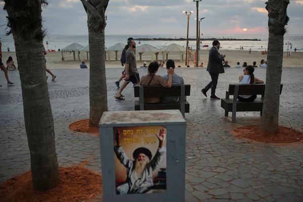 People walk along the beachfront promenade in Tel Aviv, Israel, on Saturday, June 14, 2025. (AP Photo/Ohad Zwigenberg)