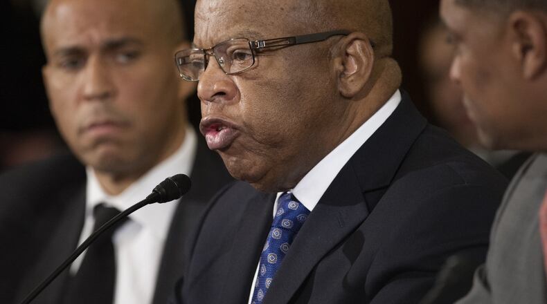 U.S. Rep. John Lewis, D-Atlanta, center, flanked by U.S. Sen. Cory Booker, D-N.J., left, and U.S. Rep. Cedric Richmond, D-La., testifies Wednesday before the Senate Judiciary Committee on the final day of a confirmation hearing for Alabama U.S. Sen. Jeff Sessions, President-elect Donald Trump’s choice for attorney general. Lewis urged the committee to reject Sessions’ nomination. (AP Photo/Cliff Owen)