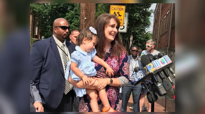 Camila Wright holds daughter Zoya, 2, as she speaks at a news conference on the anniversary of her husband Shahriar Zolfaghari's death. Zolfaghari was working as a Lyft driver when he was shot and killed. RAISA HABERSHAM / RAISA.HABERSHAM@AJC.COM