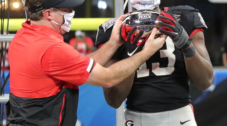 Georgia coach Kirby Smart hands outside linebacker Azeez Ojulari the trophy after beating Cincinnati in the Peach Bowl on Friday, Jan. 1, 2021, in Atlanta. Curtis Compton / Curtis.Compton@ajc.com”