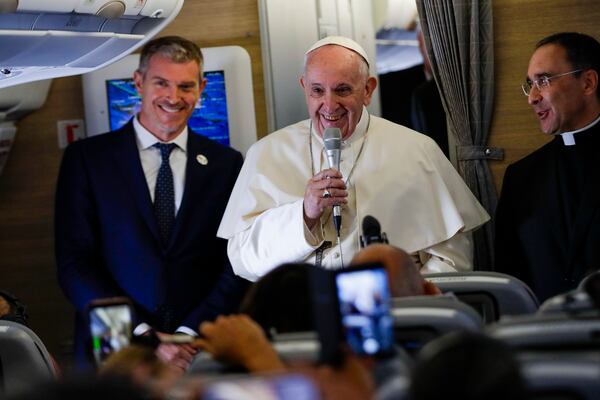 FILE - Pope Francis is flanked by his spokesperson Matteo Bruni, left, as he addresses journalists during his flight from Rome to Maputo, Mozambique, Wednesday, Sept. 4, 2019. "It’s an honor if the Americans attack me.” -- Quip to French journalist-author Nicholas Seneze, referring to U.S. conservative criticism, aboard the papal plane. (AP Photo/Alessandra Tarantino, file)