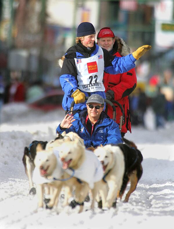 FILE - Seward, Alaska, musher Tyrell Seavey, with his grandfather, Iditarod Trail Sled Dog Race veteran Dan Seavey, on the second sled, right, and Dan Freitas in the front sled, drives his dog team down 4th Avenue in Anchorage, Alaska, Saturday, March 5, 2005, during the ceremonial start of the Iditarod Trail Sled Dog Race. (AP Photo/Al Grillo,File)