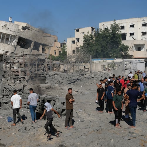 Palestinians gather around the site of an Israeli military drone strike on a blacksmith shop in Gaza City's Sabra neighborhood killing at least four Palestinians and wounded another, according to officials at Shifa hospital, where the casualties were taken on Sunday, July 12, 2026. (AP Photo/Jehad Alshrafi)