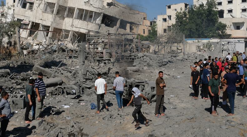 Palestinians gather around the site of an Israeli military drone strike on a blacksmith shop in Gaza City's Sabra neighborhood killing at least four Palestinians and wounded another, according to officials at Shifa hospital, where the casualties were taken on Sunday, July 12, 2026. (AP Photo/Jehad Alshrafi)