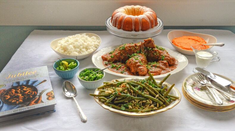 191202 Atlanta, Ga: Compilation shot: Starting from front. Toni Tipton-Martin’s Green Bean Amandine, blanched haricots verts tossed in butter, olive oil and garlic and perked up with paprika, is a study in simplicity. From her cookbook, “Jubilee: Recipes from Two Centuries of African American Cooking” (Clarkson Potter, $35), the side is elegant elegant enough for company or the holiday table. Braised Lamb Shanks with Peanut Sauce is Toni Tipton-Martin’s take on the various peanut-enriched stews of West Africa, specifically Senegal’s mafe. The recipe, from her cookbook, “Jubilee: Recipes from Two Centuries of African American Cooking” (Clarkson-Potter, $35), is served with rice and rof gremolata, a condiment of chopped parsley, garlic, lemon zest and Scotch bonnet pepper that marries Senegal’s rof and Italy’s gremolata. (in small condiment dish) Rof gremolata helps cut the richness of Toni Tipton-Martin’s Senegalese-inspired Braised Lamb Shanks with Peanut Sauce. It’s also a delicious, all-purpose condiment that will pair well with most any roasted, grilled or braised meat, fish or chicken. Recipe is from Tipton-Martin’s cookbook, “Jubilee: Recipes from Two Centuries of African American Cooking” (Clarkson Potter, $35). (cake) Toni Tipton-Martin bakes her Lemon Tea Cake at Christmastime; it’s a triple-lemon affair of zesty yellow cake, drizzled with lemon syrup and crowned with an optional lemon glaze. Recipe is from her cookbook, “Jubilee: Recipes from Two Centuries of African American Cooking” (Clarkson Potter, $35). (far right in dish) A dollop of cream and a splash of rum gives smashed carrots and turnips a haunting sweetness. The dish is a welcome diversion from sweet potatoes. Recipe is from Toni-Tipton Martin’s important new cookbook, “Jubilee: Recipes from Two Centuries of African American Cooking” (Clarkson Potter, $35). Food cover story. A conversation with cookbook author Toni Tipton-Martin about her new book, “Jubilee: Recipes for two Centuries of African