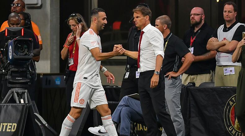 Atlanta United's Justin Meram (14) is congratulated by head coach Frank de Boer (right) after being subbed off against the Montreal Impact June 29, 2019, at Mercedes Benz Stadium in Atlanta. (Rich von Biberstein/Icon Sportswire)
