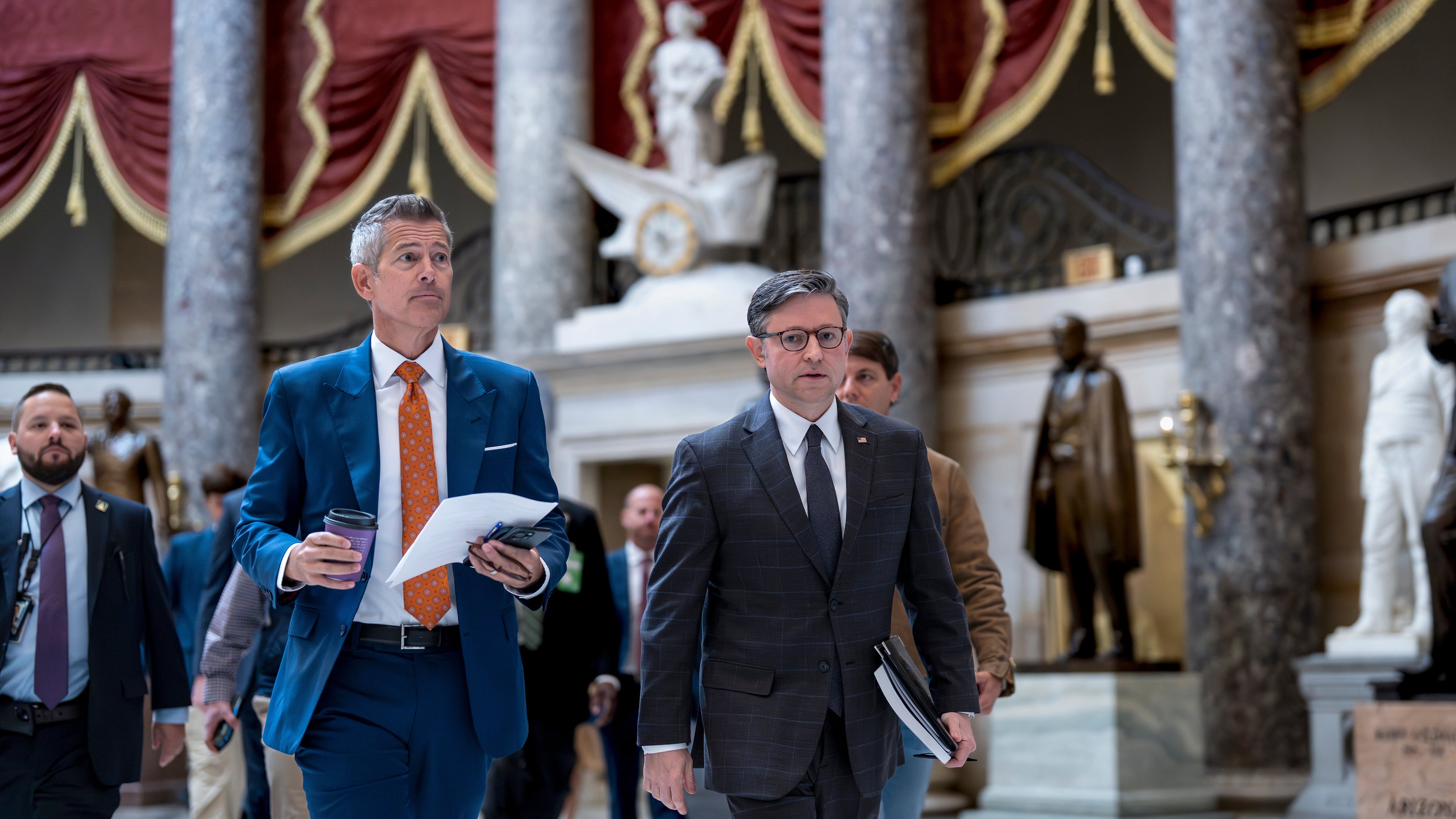 Transportation Secretary Sean Duffy, left, and Speaker of the House Mike Johnson, R-La., walk through Statuary Hall at the Capitol to a news conference on day 23 of the government shutdown, in Washington, Thursday, Oct. 23, 2025. (AP Photo/J. Scott Applewhite)