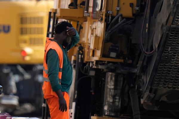 FILE - An employee takes a break as he works at a road construction site in Milan, Italy, July 1, 2025. (AP Photo/Luca Bruno, File)