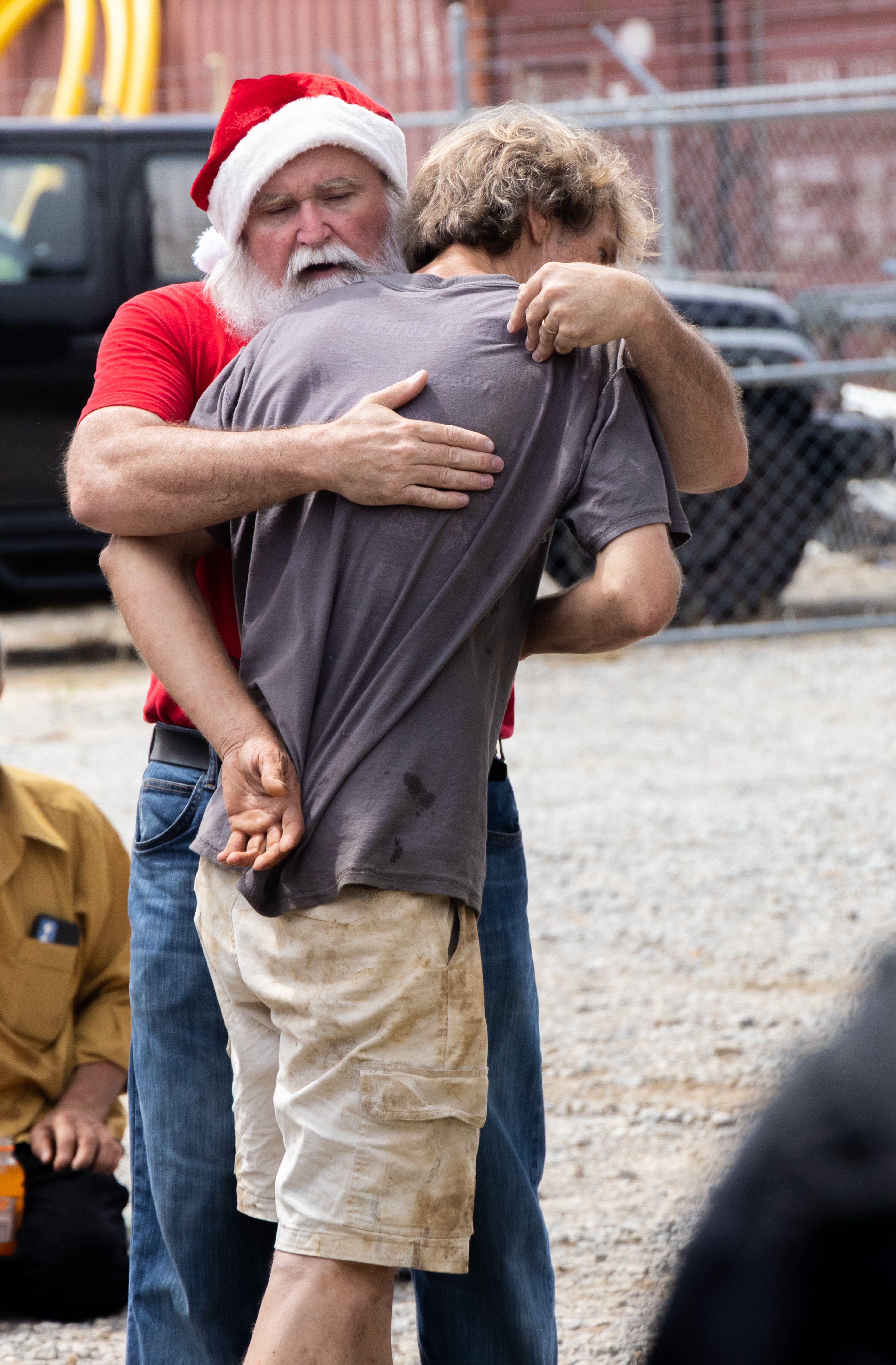 Randy Smith, aka "Santa Randy," comforts a man near a homeless encampment in Gainesville. (Phil Skinner for the AJC)