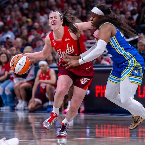 Indiana Fever guard Caitlin Clark (22) reacts as she makes contact with the defense of Dallas Wings guard Arike Ogunbowale (24) during the first half of an WNBA basketball game in Indianapolis, Saturday, May 9, 2026. (AP Photo/Doug McSchooler)